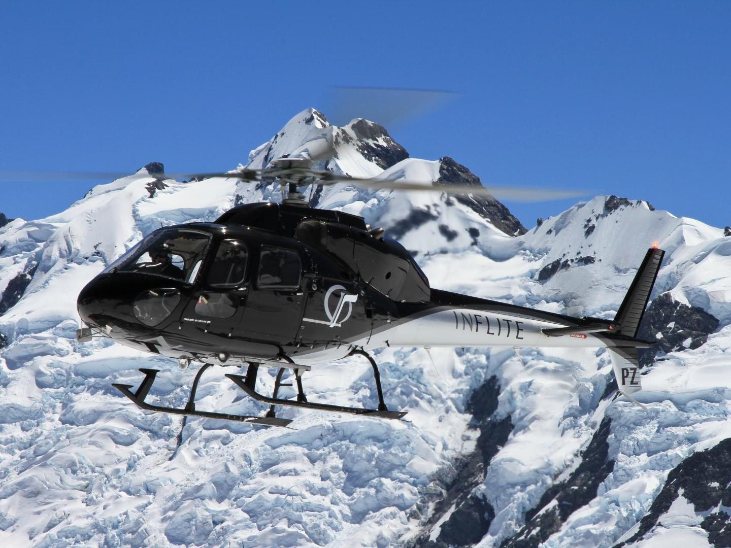 Black helicopter flying over Mt Cook