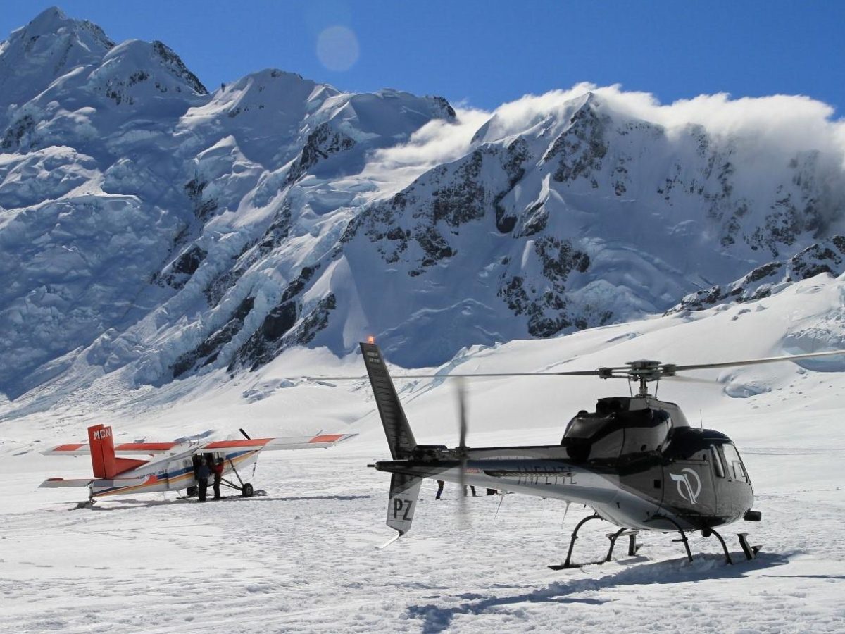 Ski plane and helicopter lands on mt cook
