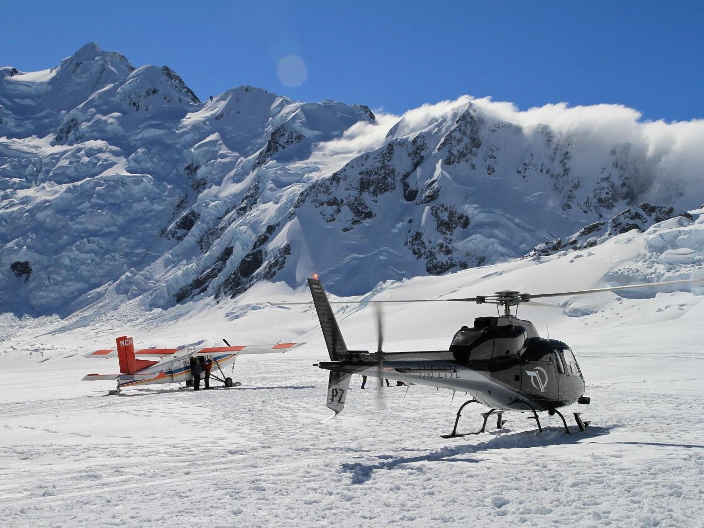 Ski plane and helicopter lands on mt cook