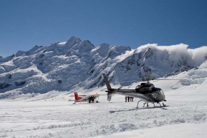 Ski plane and helicopter lands on mt cook