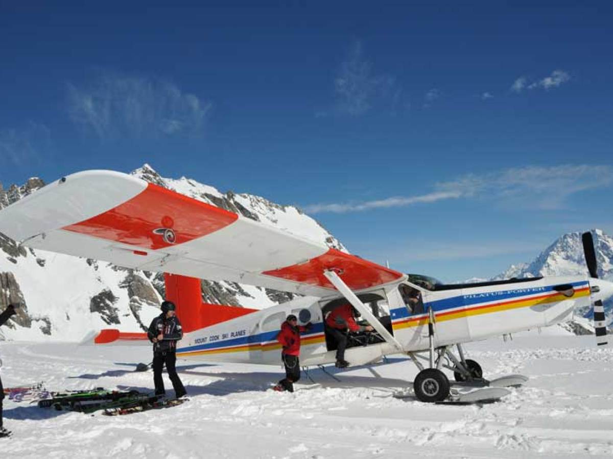 4 people getting on board on ski planes