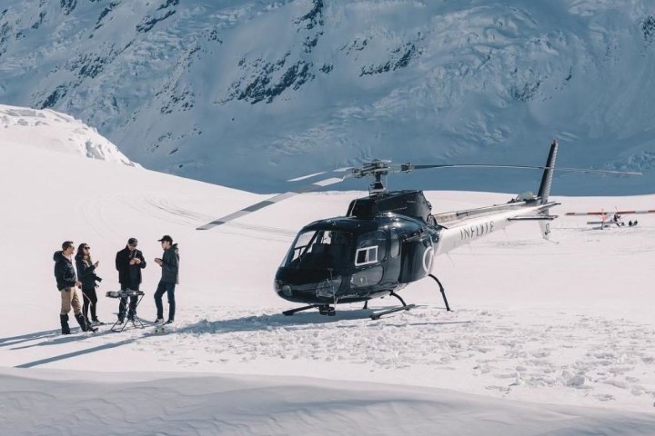 a group of people standing on top of a snow covered mountain