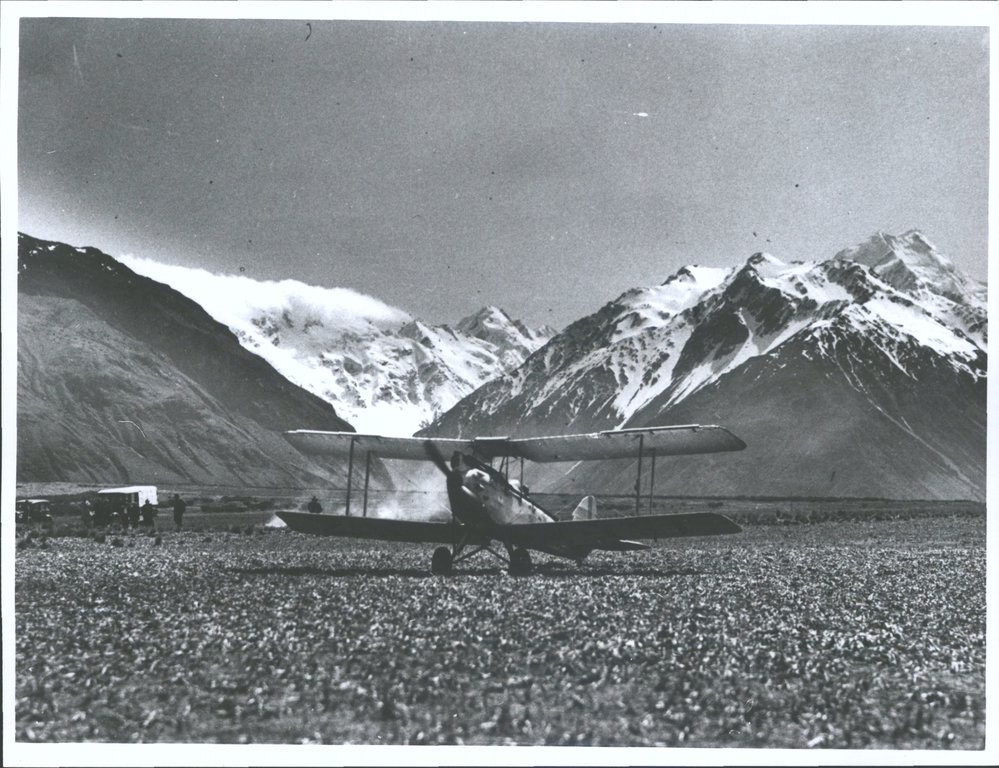 PLANE AT MTC a group of people standing in front of a mountain
