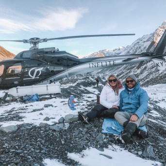 a person sitting on top of a snow covered mountain