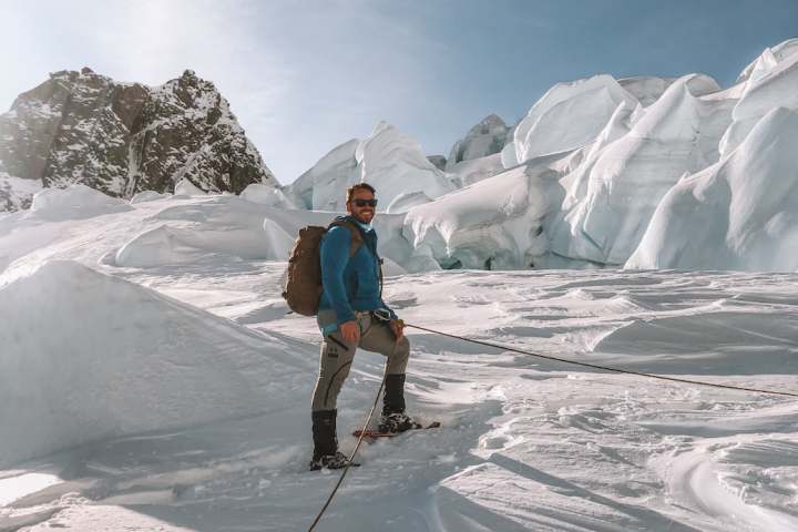 a man riding skis down a snow covered mountain