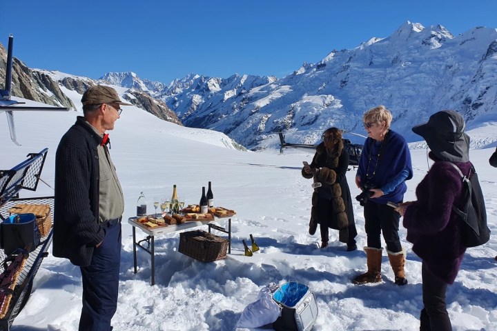 a group of people standing on top of a snow covered mountain