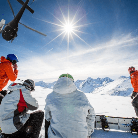 a group of people standing on top of a snow covered slope