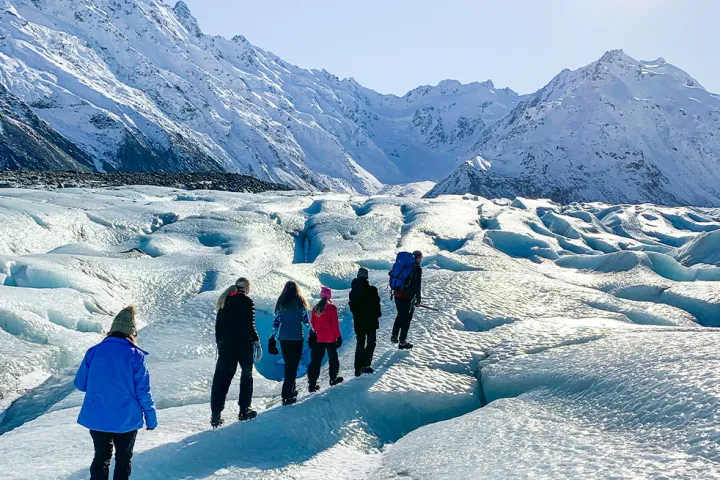 a group of people standing on top of a snow covered mountain