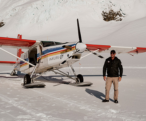 a group of people standing around a plane