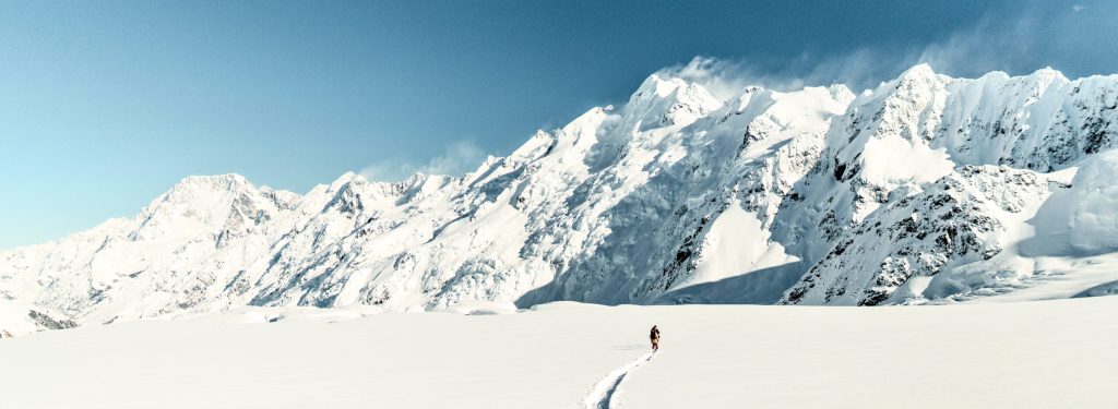 a group of people standing on top of a snow covered mountain