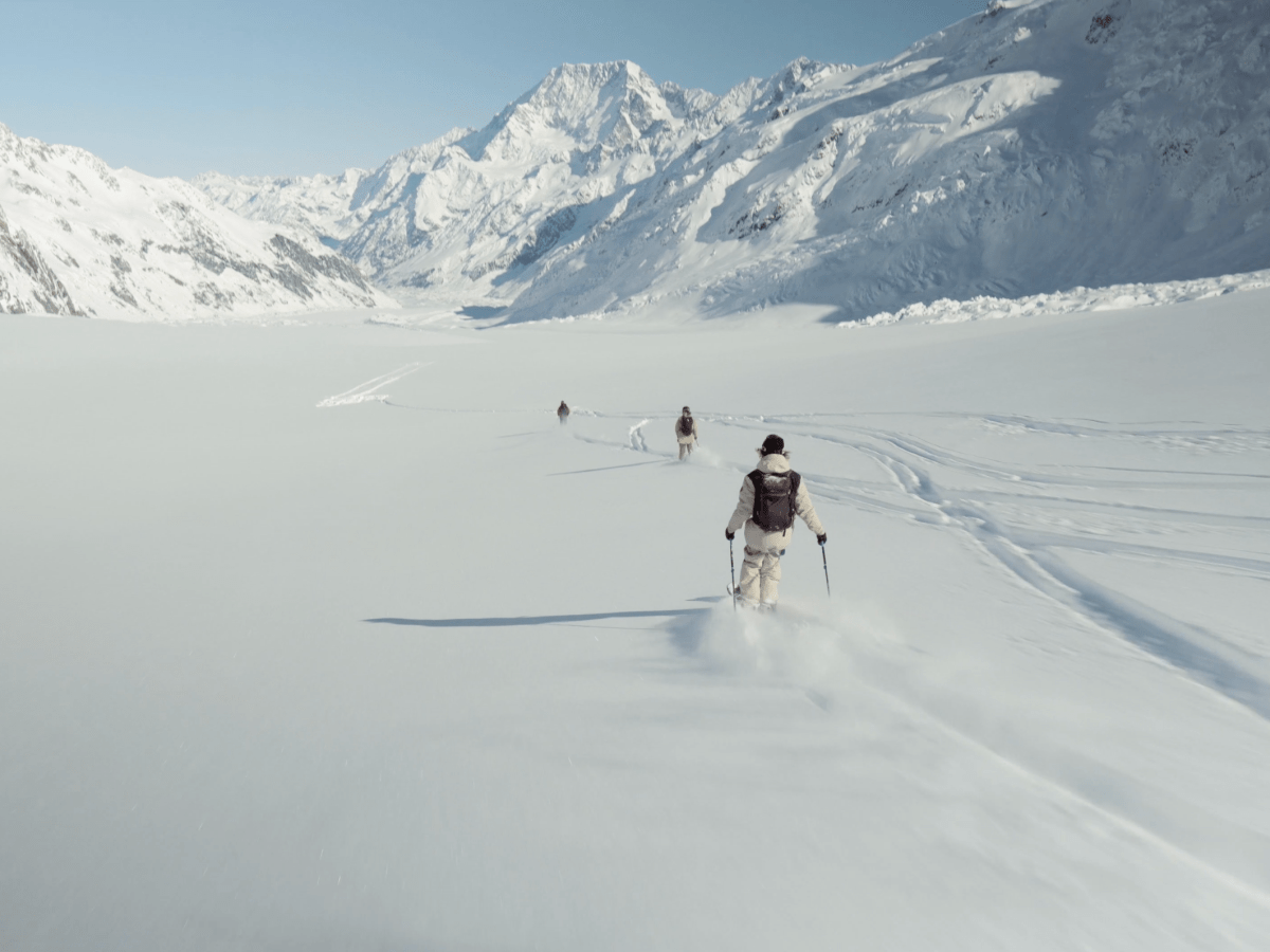 a man riding skis down a snow covered mountain