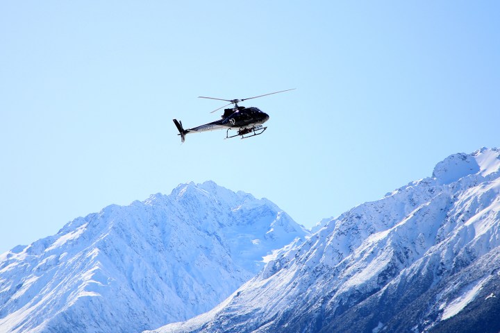 Helicopter flies above southern alp mountains in mt cook