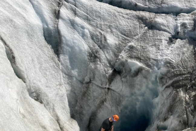 a man standing on a rock in the snow