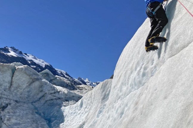 a man riding skis down a snow covered mountain