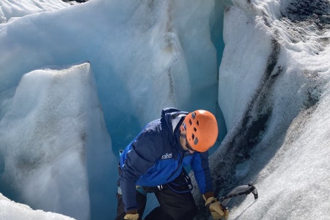 a man riding a snowboard down a snow covered mountain