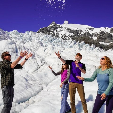 a group of people standing on top of a snow covered mountain