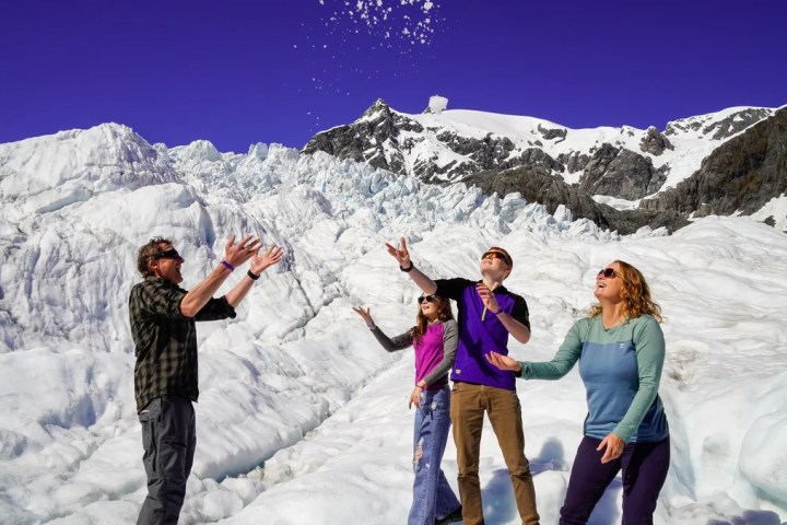 a group of people standing on top of a snow covered mountain