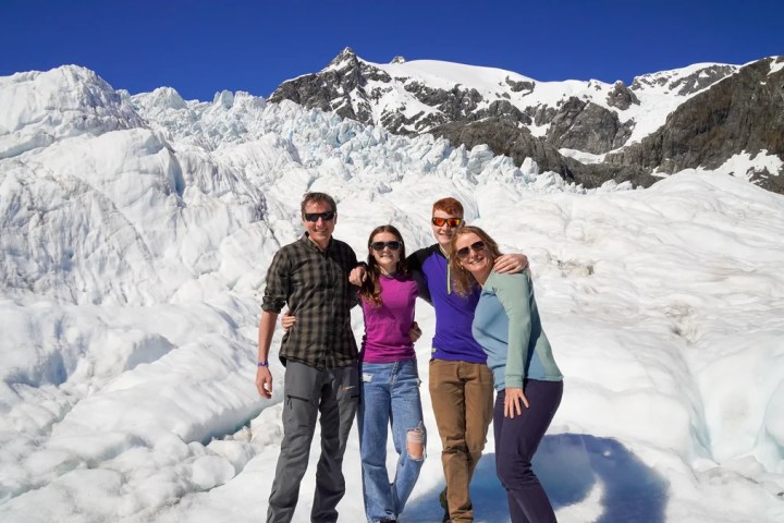 a man and a woman standing in front of a snow covered mountain