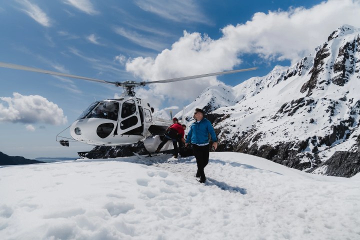 a man standing on top of a snow covered slope