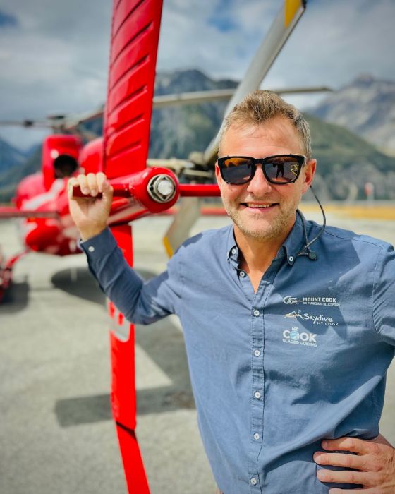 a man wearing sunglasses and holding a kite