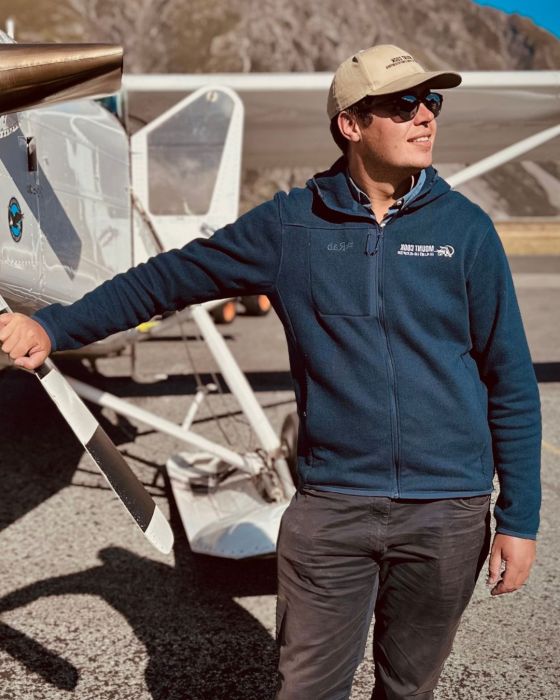 a person standing next to a fixed wing aircraft