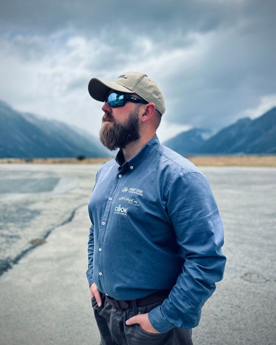 a man standing next to a body of water