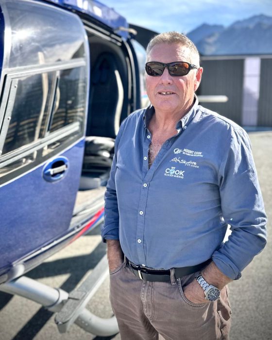 a man standing in front of a blue car