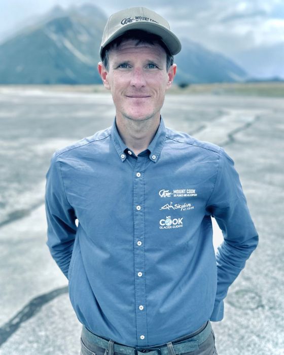 a man posing for the camera in a helicopter field