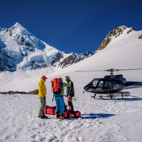 a group of people riding skis on top of a snow covered mountain