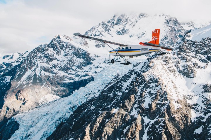 a man flying through the air on a snow covered mountain